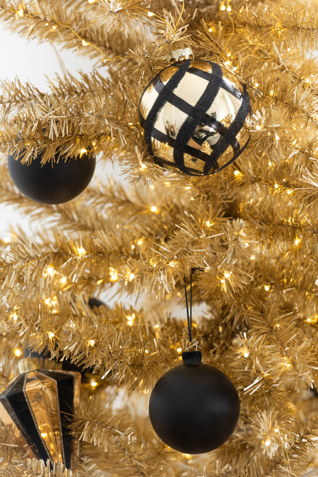 Doos van 4 kerstbal geruit glas goudkleurig/zwart