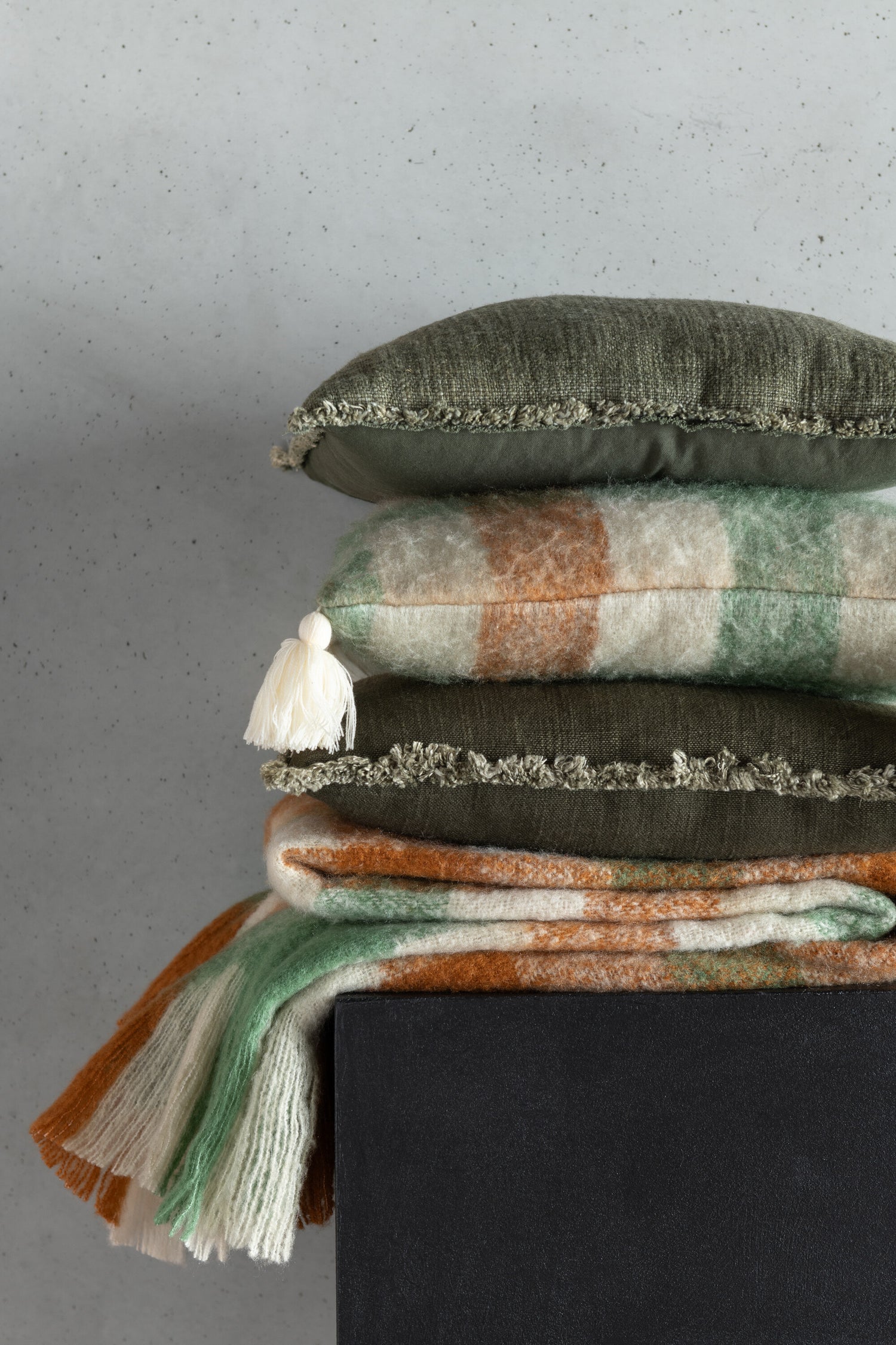 Kussen met rafelige randen van polyester/katoen in donkergroen.