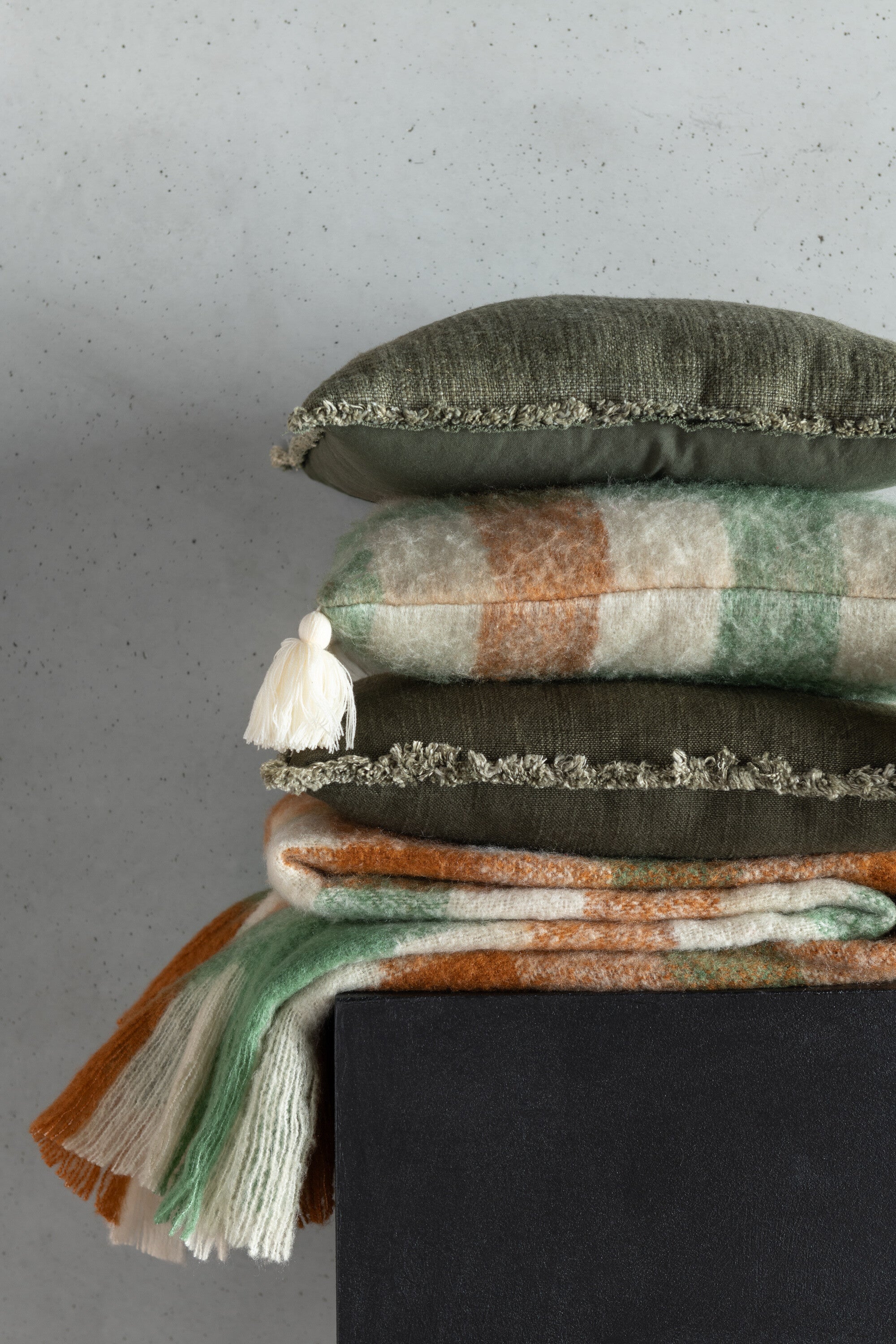 Kussen met rafelige randen van polyester/katoen in donkergroen.